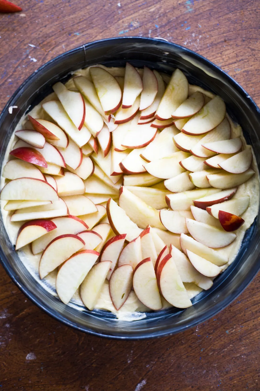 Sliced red apples arranged in a cake tin