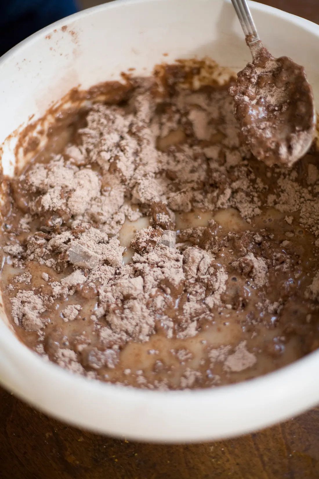 Chocolate muffin mixture in a white mixing bowl