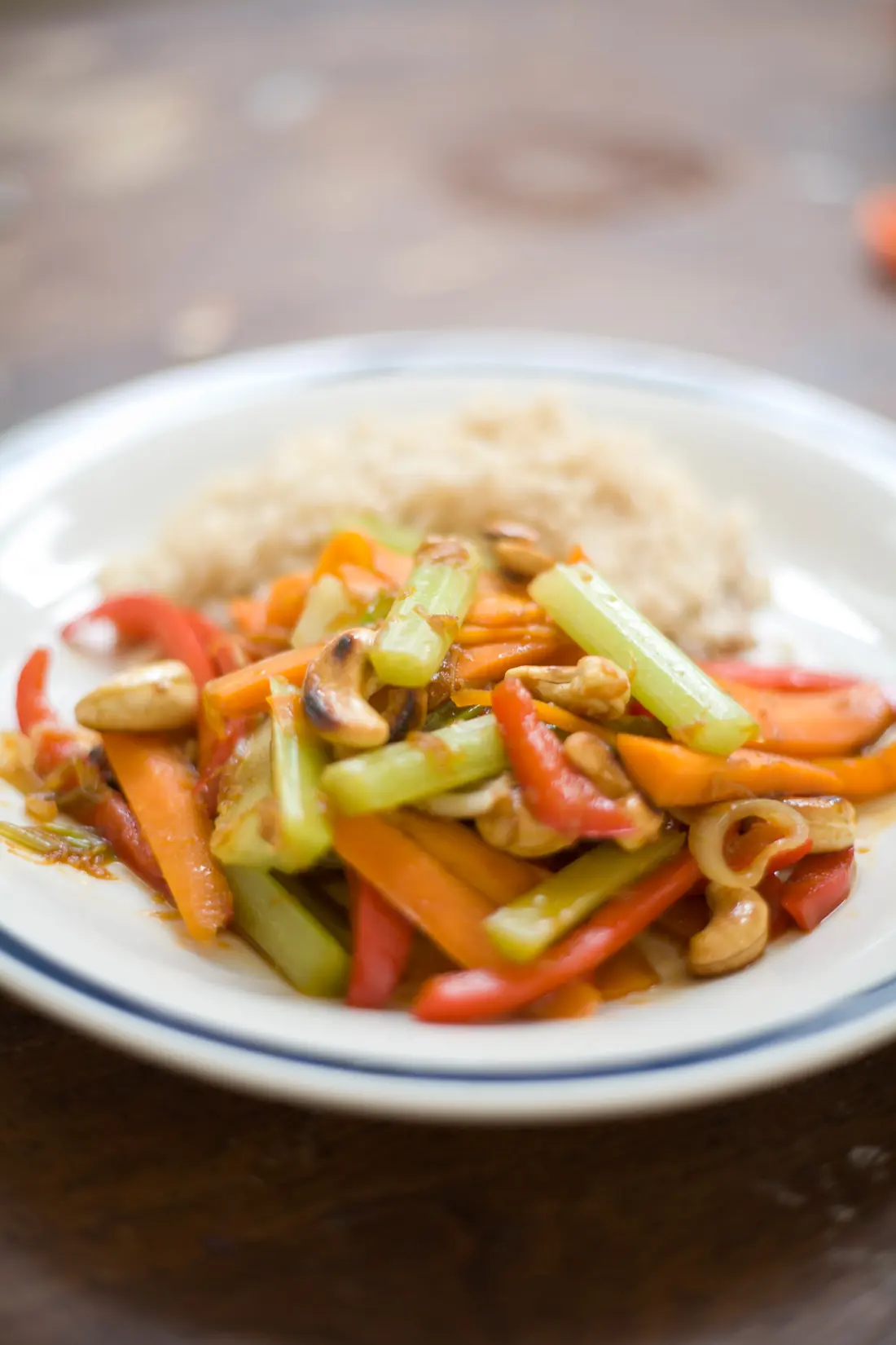 A stir fry of carrot, celery and cashews on rice